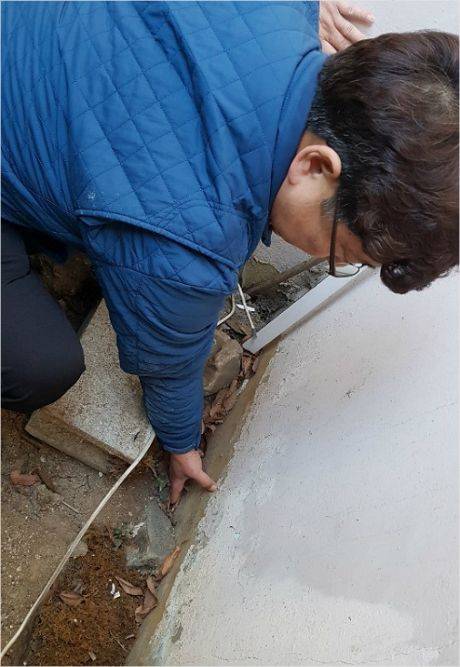 인천 삼두1차아파트는 지난 2015년 지하 50m 지점에서 '북항터널' 공사가 진행된 이후, 지반 침하 및 균열 현상이 나타나고 있다. 사진은 지반 침하로 인해 페인트칠을 하지 않은 벽면이 지면 위로 드러난 모습. (사진=윤철원기자)