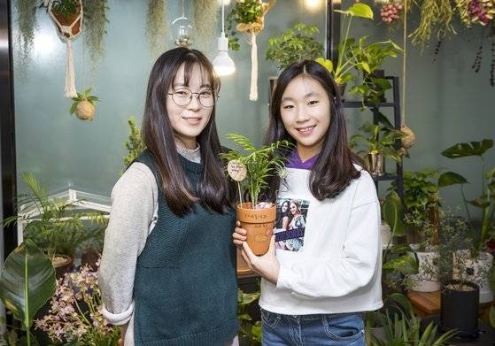 배지영(오른쪽) 학생모델이 채송화 복지원예사의 도움을 받아 테이블야자를 토분에 옮겨 심고 나만의 화분으로 꾸몄다.
