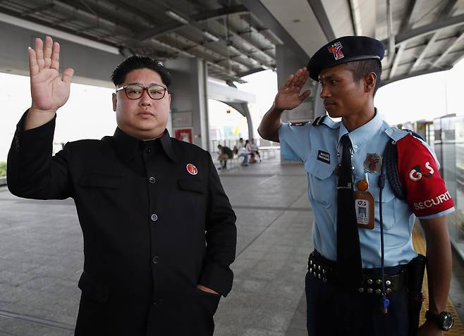 태국 사뮤트 프라칸주의 한 스카이트레인 플랫폼에서 북한 김정은 국무위원장을 닮은 우텐 루앙상통 씨가 17일 (현지시간) 안전요원으로부터 거수경례를 받고 있다. [EPA=연합뉴스]