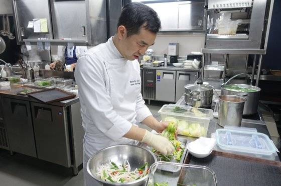 권우중 셰프가 절인 배추에 소를 넣고 있다.