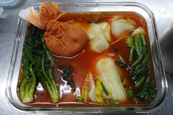 김치 담그기가 끝난 상태. 걸러진 양념 알갱이는 베 보자기를 여며 실로 묶어 김치 통에 함께 넣는다.