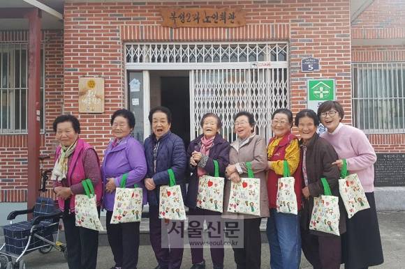 김정숙 여사가 ‘세계 여성의 날’을 하루 앞둔 지난 7일 영화 ‘칠곡 가시나들’의 주인공 할머니들에게 편지와 할머니들이 직접 그린 그림과 이름이 프린팅된 책주머니를 보냈다. 사진은 ‘칠곡 가시나들’ 출연진들이 김정숙 여사가 선물한 책주머니를 들고 포즈를 취하고 있다. [사진=단유필름 제공]