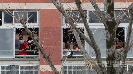 전두환 전 대통령이 광주지법으로 출두한 11일 낮 12시30분쯤 법원 맞은편 동산초등학교 학생들이 창가에서 구경하고 있다. 광주=최현규 기자