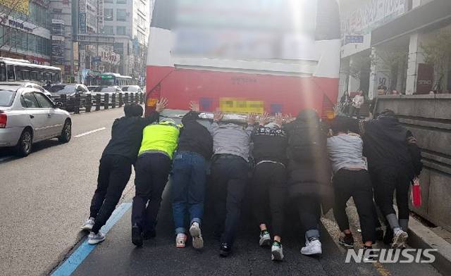 【부산=뉴시스】  지난 9일 부산 남구 경성대 앞 교차로에서 고장으로 멈춰선 좌석버스를 경찰과 시민 등이 힘을 합쳐 이동시키고 있다. 2019.03.11. (사진=부산경찰청 제공)photo@newsis.com