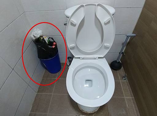 변기 옆 작은 휴지통에는 일회용 플라스틱 용기부터 생활 쓰레기까지 가득 차 있다.