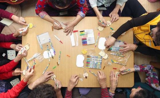 치매 예방을 위한 온·오프라인 교육활동이 활발하다. 뇌운동을 많이, 꾸준히 하면 뇌기능 저하와 치매 발병 확률을 낮출 수 있다. 사진은 열쇠고리를 만들며 치매 예방 프로그램에 참여하는 어르신들과 강사. 강정현 기자.