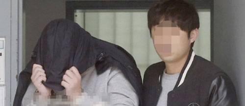 `청담동 주식 부자` 이희진 씨 부모 살해 용의자 김모(34) 씨가 18일 오전 경기도 안양시 동안경찰서에서 조사를 받기 위해 이동하고 있다. 경찰은 나머지 용의자 3명을 쫓고 있다. [연합뉴스]