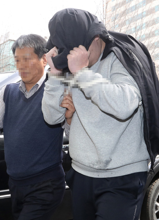 ‘청담동 주식부자’ 이희진씨 부모의 살해 용의자 김모(34·오른쪽)씨가 지난 18일 오전 경기도 안양시 동안경찰서에서 조사를 받기 위해 이동하고 있다. 경찰은 나머지 용의자 3명을 쫓고 있다. 안양=연합뉴스