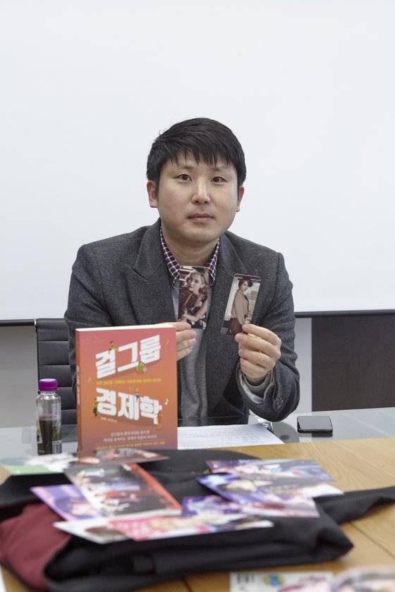 유성운 작가가 포토카드를 들어 보이며 설명하고 있다. 그는 소녀시대 골수팬으로 특히 윤아, 서현을 좋아한다. 일하는 사무실 벽에 그들의 사진을 붙여두고 힘을 얻기도 한다는 게 그의 말이다.