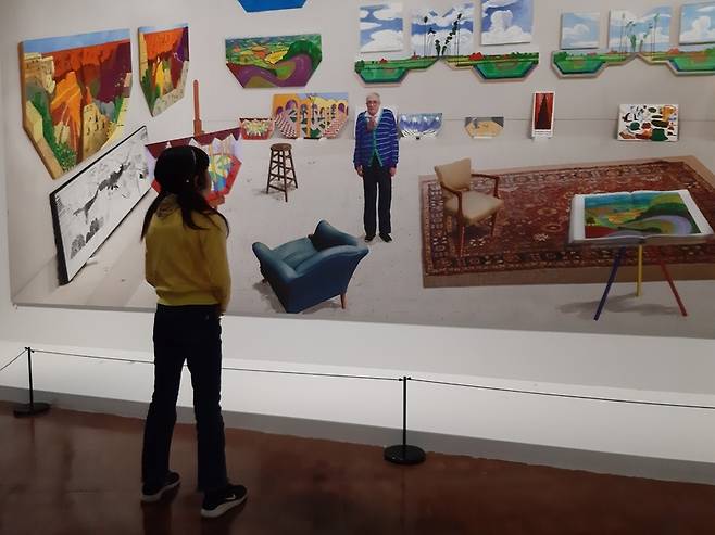 전시장의 마지막 작품인 ‘2017년 2월 스튜디오’의 풍경 앞에서 한 어린이 관객이 그림 속 호크니를 바라보고 있다. 호크니와 어린이가 묵시의 대화를 하는 듯한 구도가 흥미롭게 비친다.