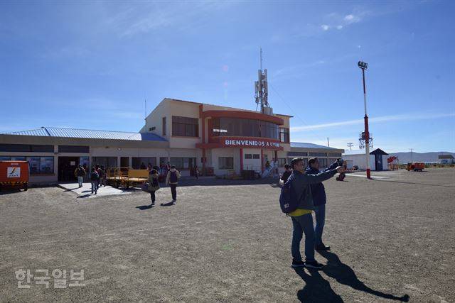 여행객들이 우유니 공항을 배경으로 기념사진을 찍고 있다.