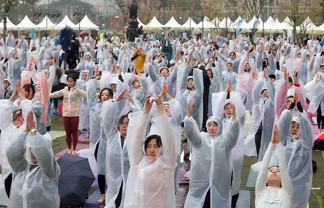 롯데백화점은 14일 창립 40주년을 기념해 전세계에서 가장 큰 요가행사인 '요가 말라 프로젝트'를 유통업계 최초로 개최했다. 이날 비가 내리는 가운데 500여명의 요가 애호가들이 롯데백화점 잠실점 월드파크에서 '108 수리야나마스카라'를 하고 있다. 최정동 기자