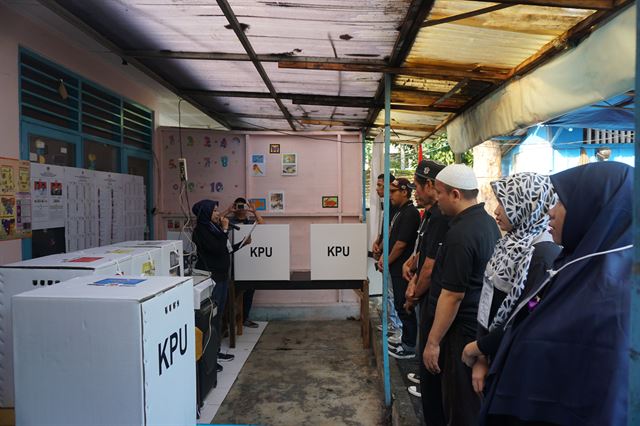 17일 인도네시아 자카르타 대선 투표소에서 선거관리요원들이 투표 시작 전 소리 내 공명선거를 다짐하고 있다. 자카르타=고찬유 특파원