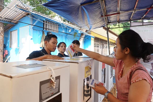 17일 인도네시아 자카르타 대선 투표소에서 한 시민이 기표를 마친 투표용지를 색깔이 같은 투표함에 넣고 있다. 자카르타=고찬유 특파원/2019-04-17(한국일보)