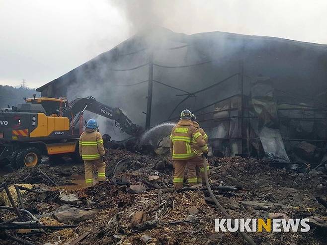 소방대원들이 산불현장 아래 대형 창고에 붙은 불을 끄고 있다.소방대원들은 10kg가 넘는 공기호흡기 외에 두꺼운 방화복에 방화 헬멧, 방화두건, 방수화를 신고 화재를 진압한다.  일반인들은 한발짝 걷기도 어려운 무게다. 소방공무원은 강인한 정신력과 국가관, 체력을 요구한다.