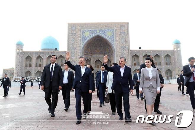 문재인 대통령이 20일 우즈베키스탄 역사문화유적지 사마르칸트에 있는 레기스탄 광장에서 미르지요예프 대통령과 시민들을 향해 손을 흔들고 있다.