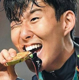 아시안게임 금메달을 물고 있는 손흥민. /조선DB