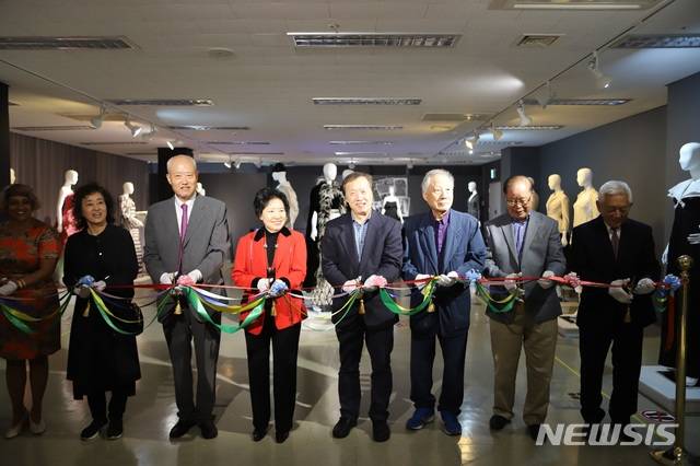 [사진설명] 인천 송도에 있는 한국뉴욕주립대 현대의상박물관에서 열린 ‘FIT와 한국패션’ 전시회 개막식에서 김춘호 한국뉴욕주립대 총장(왼쪽 두번째), 신혜순 현대의상박물관장 등 참가자들이 테이프를 자르고 있다.(사진= 한국뉴욕주립대 제공)