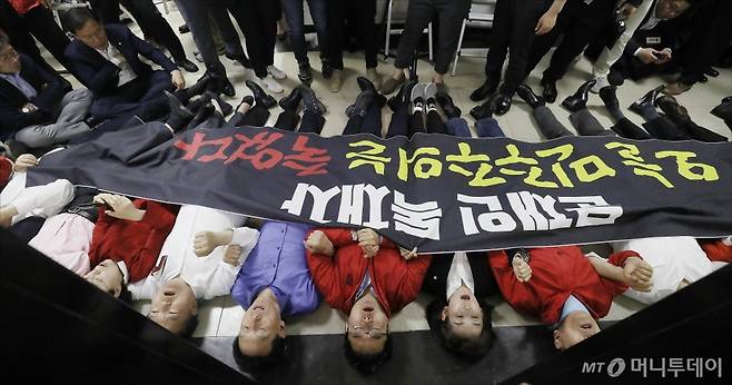 자유한국당 나경원 원내대표와 의원들이 29일 오후 서울 여의도 국회 본청에서 열린 국회 사법개혁특별위원회(사개특위) 전체회의에서 검경수사권과 공수처 설치법의 패스트트랙이 통과되자 회의장 앞에 누워 항의를 하고 있다./사진=이동훈 기자