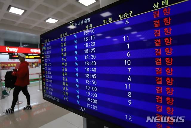 【제주=뉴시스】조수진 기자 = 5일 윈드시어경보와 태풍경보가 내려진 제주국제공항을 오가는 항공편이 오후 6시부터 전편 결항됐다. 한 공항 이용객이 결항 일정으로 가득 채워진 제주공항 입국장에 설치된 운항 스케쥴 모니터를 지나고 있다. 2018.10.05.  susie@newsis.com