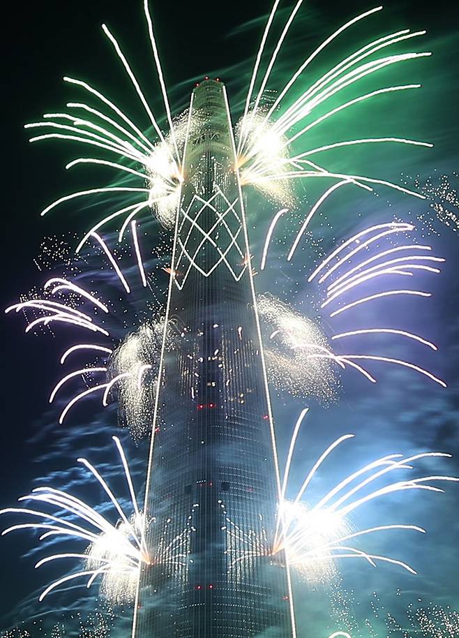 4일 밤 서울 송파구 롯데월드타워에서 열린 '롯데월드타워 불꽃축제'에서 화려한 불꽃들이 타워 주위를 수놓고 있다. [뉴시스]
