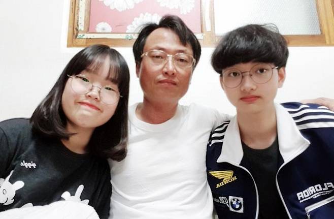 초등학생 때 쓴 동시 '가장 받고 싶은 상'이 동요로 만들어진 이슬(왼쪽)양이 전북 부안군의 자택에서 아버지 이성(가운데)씨, 오빠 이서인군과 나란히 앉아 사진을 찍었다. /이성씨 제공