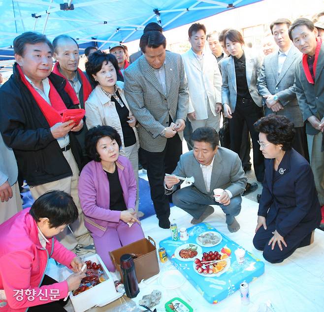 부산상고(현재 개성고) 운동장에서 열린 동문체육대회에 참석한 노무현 대통령이 쪼그려 앉은 채 나무젓가락으로 음식을 먹고 있다. 2007.4.8 ⓒ 장철영