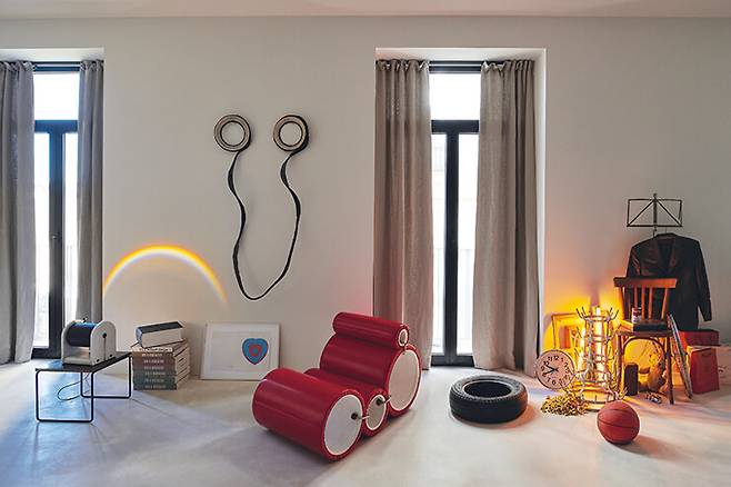 거실에 있는 예술 작품들이 공간에 생동감을 불어넣는다. 왼쪽부터 50년대에 피에르 귀아리슈가 디자인한 사이드 테이블. 그 위에 놓인 것은 1980년대 스튜디오 알키미아가 제작한 램프로 벽에 걸린 파올로 카네바리(Paolo Canevari)의 작품과 조화를 이루며 벽면에 시적인 무지개를 비춰준다. 그 옆에는 마르셀 뒤샹의 책들과 조 콜롬보가 1968년에 디자인한 ‘튜브’ 체어가 놓여 있다. 오른쪽에는 스위스 출신의 존 암리더(John Armleder)의 설치미술 작품 ‘Don’t Do It!’이 자리했는데, 뒤샹부터 워홀에 이르기까지 유명한 근현대 예술가들의 작품을 인용한 것이다.