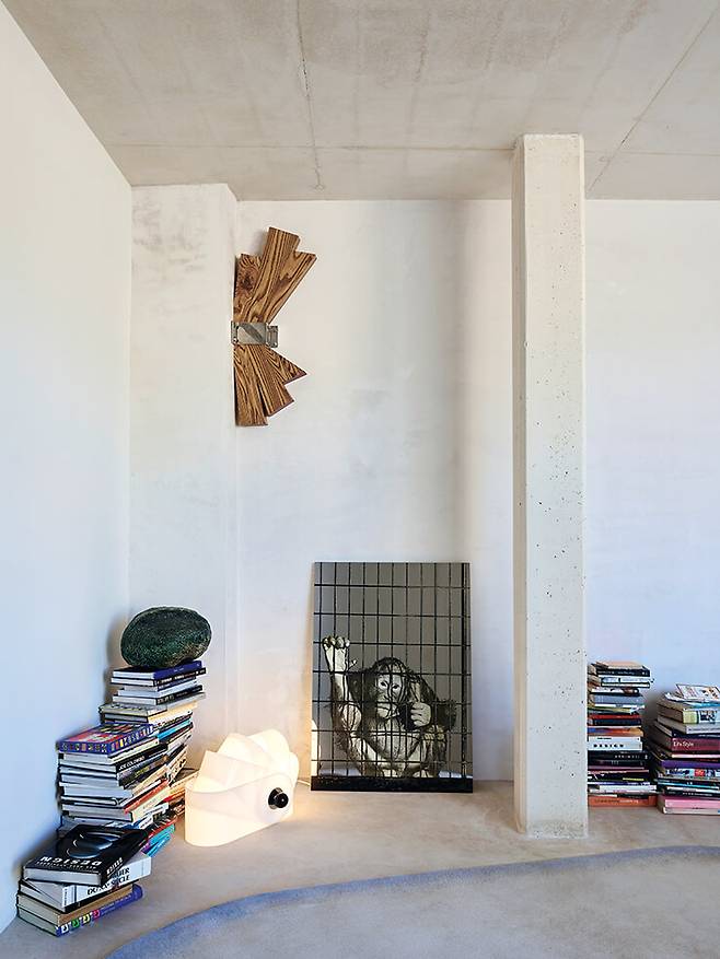 침실 한쪽 책 더미 옆에 수퍼스튜디오가 1967년에 디자인한 램프와 미켈란젤로 피스톨레토(Michelangelo Pistoletto)의 실크스크린 작품이 놓여 있다. 벽에 걸린 오브제는 아트슈와거(Artschwager)의 조각 작품. 아래 사진은 골목에서 바라 본 입구. 본래 건물의 파사드가 남아 있다.