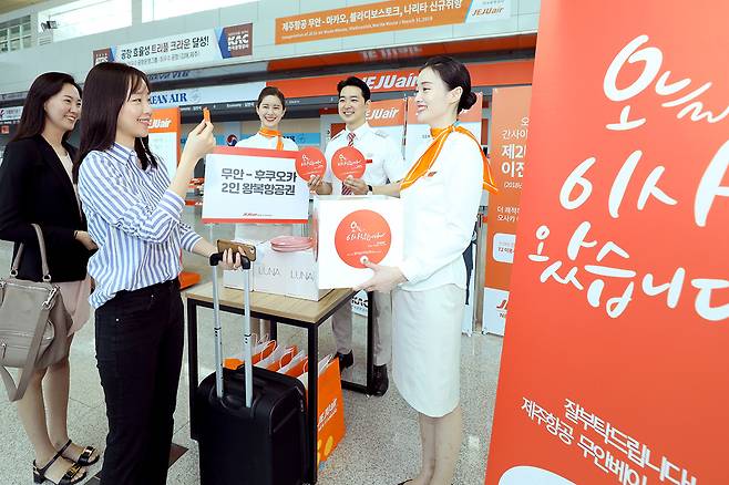 지난 23일 오후 무안국제공항 제주항공 체크인 카운터 앞에서 고객들을 대상으로 제주항공 무안베이스 오픈 이벤트를 진행하고 있다. [제주항공 제공]