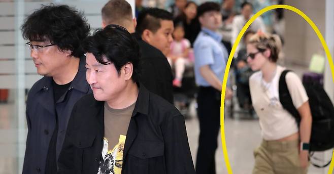 칸 국제영화제에서 영화 ‘기생충’으로 황금종려상을 수상한 봉준호 감독과 배우 송강호가 27일 오후 인천국제공항 제2여객터미널을 통해 입국하고 있다. 뒤쪽으로 패션브랜드 프로모션 참석차 입국한 영화배우 크리스틴 스튜어트가 보인다. [뉴스1]