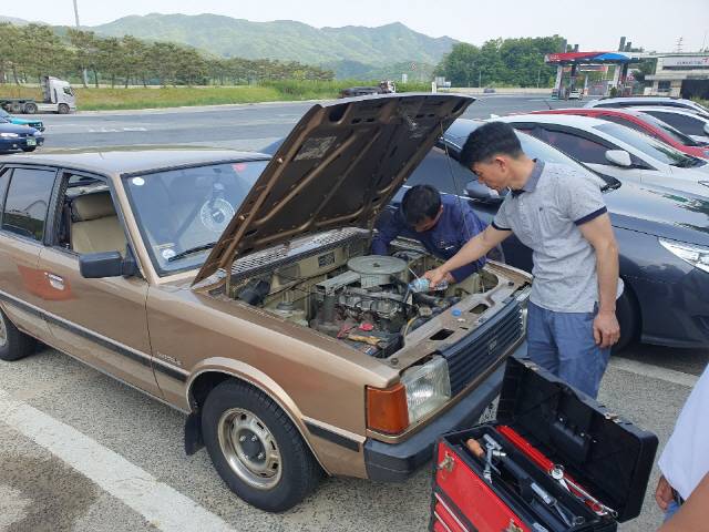 동호회원들이 장거리 운행중 휴게소에 들러 차량 상태를 점검하고 있다.