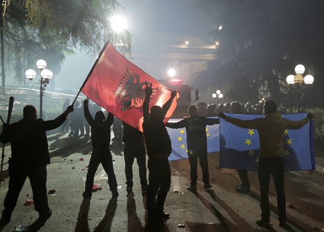 알바니아의 수도 티라나의 의사당 앞에서 2일(현지시간) 야당 지지자들이 에디 라마 총리 사임 및 조기 총선을 요구하며 시위를 하고 있는 가운데 진압 경찰 앞에 선 시위자들이 알바이나 국기와 EU 깃발을 들고 구호를 외치고 있다.  EPA 연합뉴스