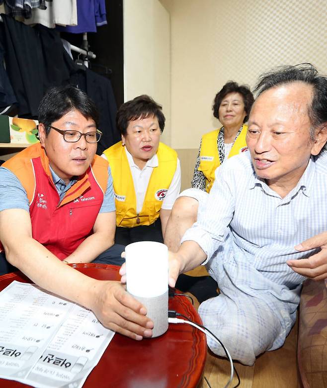 행복커뮤니티 봉사단이 독거 어르신 댁을 방문해 누구(NUGU) 사용법을 안내하고 있다.