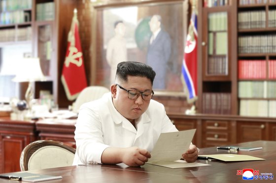 김정은 북한 국무위원장이 집무실로 보이는 공간에서 도널드 트럼프 미국 대통령의 친서를 읽는 모습을 조선중앙통신이 23일 공개했다. [조선중앙통신=연합뉴스]