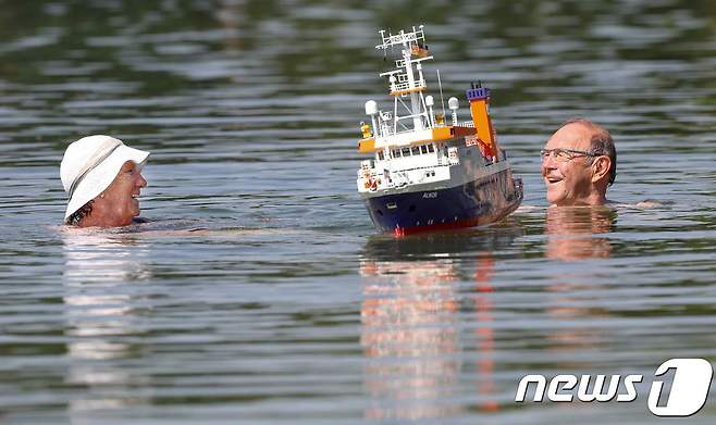 독일 에팅겐의 한 호수에서 노부부가 모형 배를 띄우면서 놀고 있다.  © AFP=뉴스1