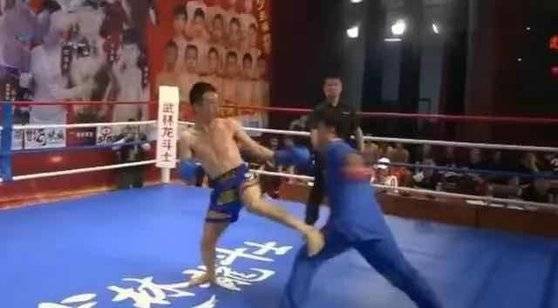 위아래 파란색 도복을 입은 훠옌산(오른쪽)이 왼쪽 손으로 반바지 차림의 중국식 격투기인 싼다 선수 치웨이화의 가슴을 때리려 하고 있다. 이 한 방에 치웨이화가 쓰러지며 경기는 끝났다. [중국 환구망 캡처]