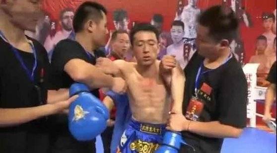 '점혈대사' 훠옌산의 일격을 받고 쓰러져 KO로 패한 중국식 격투기 싼다 선수 치웨이화가 세컨의 부축을 받아 일어나고 있다. [중국 환구망 캡처]