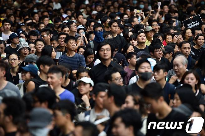 7일 중국인 관광객들 앞에서 평화 시위를 벌이고 있는 홍콩 시민들의 모습. © AFP=뉴스1