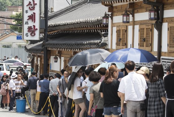 복날을 맞아 서울 종로구의 한 삼계탕 식당 앞에 줄지어 서 있는 손님들. [연합뉴스]