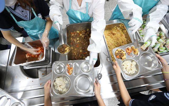 아이들에게는 신나는 점심 시간이지만, 학교 급식을 책임지는 영양교사들에게는 조마조마한 시간이다. 맛이 없다고 하면 어쩌나, 혹시 먹고 배탈 나는 아이는 없나. 배식으로 분주한 학교 급식실의 모습. 연합뉴스
