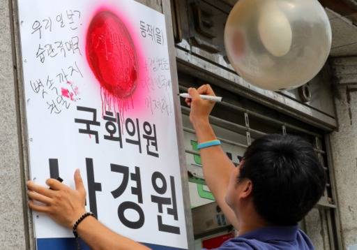 한 남성이 8일 오후 서울 동작구 나경원 자유한국당 원내대표 지역구 사무실 간판에 나 원내대표의 ‘우리 일본’ 발언에 대한 규탄 글귀를 적고 있다. 뉴시스