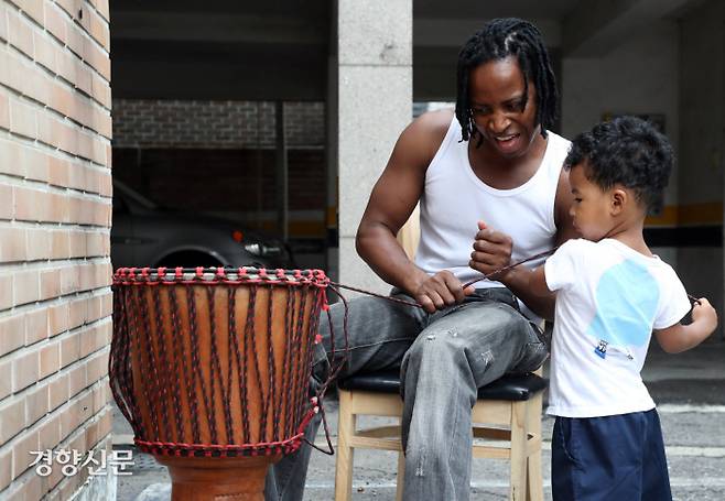아미두가 자신의 집에서 아들 루민과 함께 젬베를 만들고 있다.