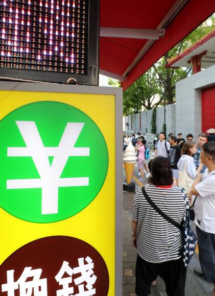 11일 오후 서울 명동에서 관광객들이 환전소에 들어서고 있다. 연합뉴스