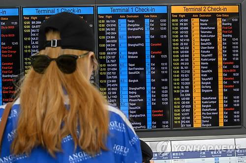 항공편 운항상황 확인하는 홍콩공항 승객 (홍콩 AFP=연합뉴스) 5일 홍콩에서 '범죄인 인도 법안'(송환법) 반대 총파업이 벌어진 가운데 홍콩 국제공항에서 한 승객이 탑승할 항공기 운항 상황을 확인하고 있다.