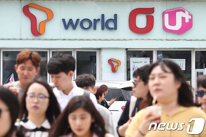 8일 오후 서울 시내의 한 이동통신 판매점 앞을 시민들이 지나고 있다.  © News1 임세영 기자