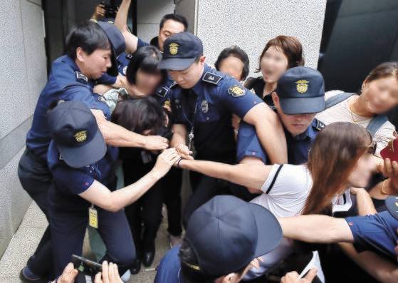 지난 12일 제주지법에서 살인 혐의 등으로 기소된 고유정(36)의 첫 정식 공판이 열린 가운데 시민들이 호송차에 오르는 고유정의 머리채를 잡아당기고 있다. [뉴시스]