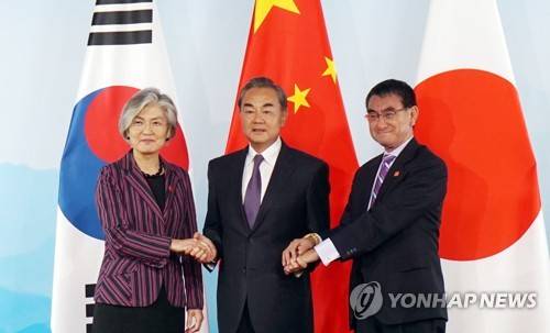 악수하는 한중일 외교장관 (베이징=연합뉴스) 21일 오전 중국 베이징(北京) 구베이수이전(古北水鎭)에서 '제9차 한·중·일 외교장관 회의'가 열리는 가운데 강경화 외교부 장관과 왕이(王毅) 중국 외교 담당 국무위원 겸 외교부장, 고노 다로(河野太郞) 일본 외무상이 회담에 앞서 기념촬영을 하고 있다. 2019.8.21 [베이징 특파원 공동취재단] chinakim@yna.co.kr