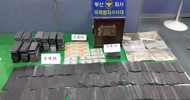 부산경찰청 국제범죄수사대가 국제 로맨스 스캠 조직원에게 압수한 증거품. 특수약물로 처리하면 달러로 변한다는 블랙머니(앞쪽)는 그냥 검은색 종이였다. 부산경찰청 제공
