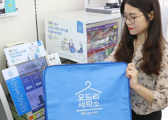 CU 이용객이 편의점 택배 서비스를 이용해 세탁물을 접수하고 있다.(사진=BGF리테일)
